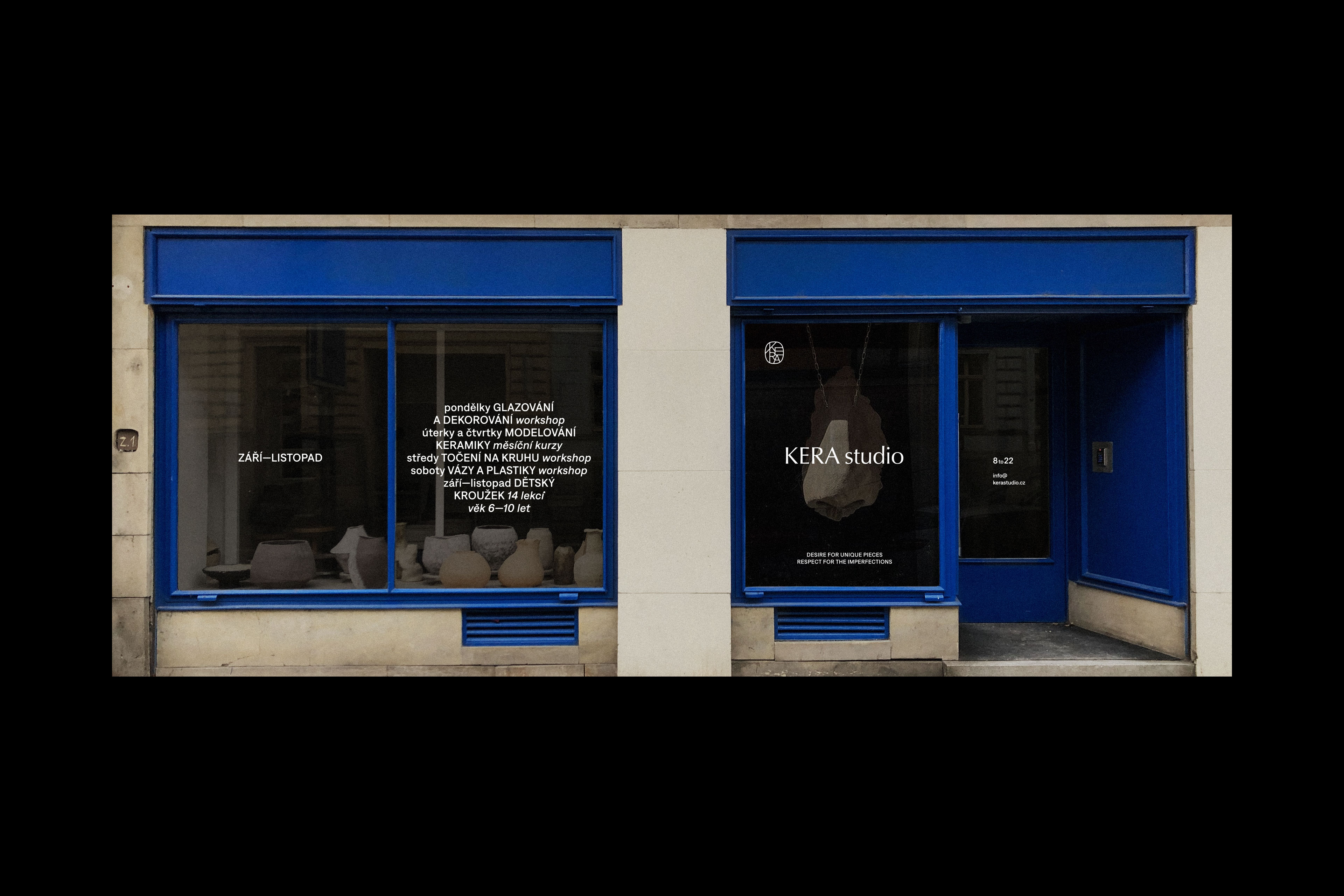 A store front with two blue windows and a clock.